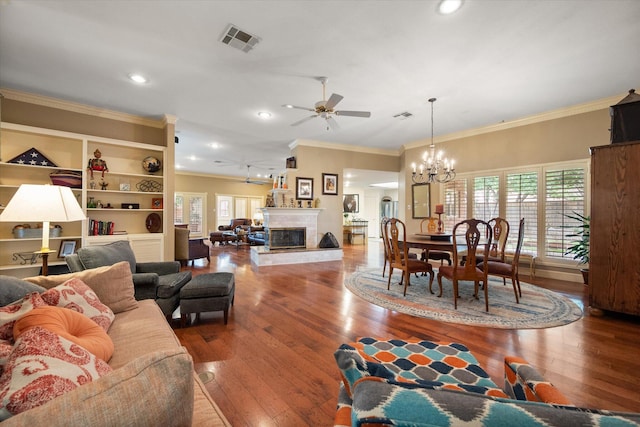 314 York Ave, Lubbock, TX 79416 - living area featuring crown molding, ceiling fan, wood finished floors, a chandelier, and a glass covered fireplace