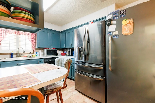 4610 63rd St, Lubbock, TX 79414 - kitchen featuring appliances with stainless steel finishes, blue cabinets, light countertops, and a textured ceiling