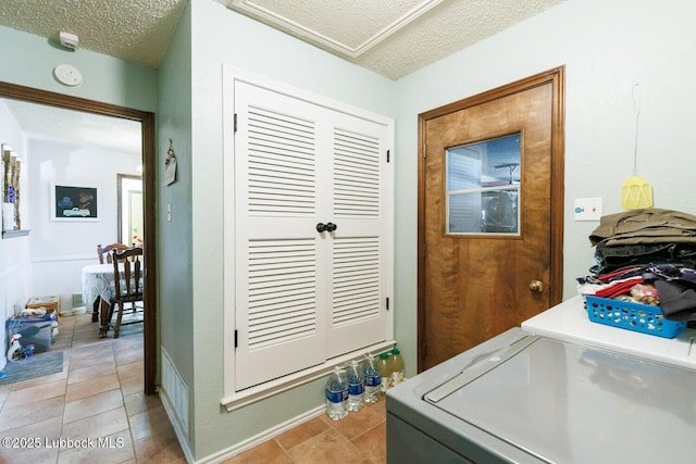4610 63rd St, Lubbock, TX 79414 - laundry room with a textured ceiling, washer and clothes dryer, and light tile patterned floors