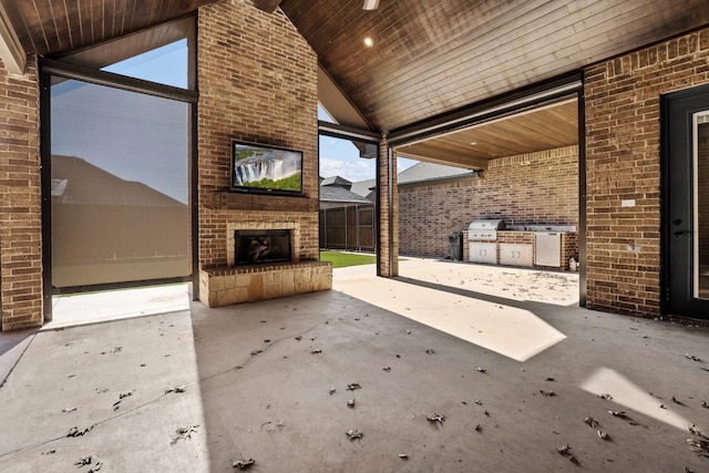 view of patio with an outdoor brick fireplace and an outdoor kitchen