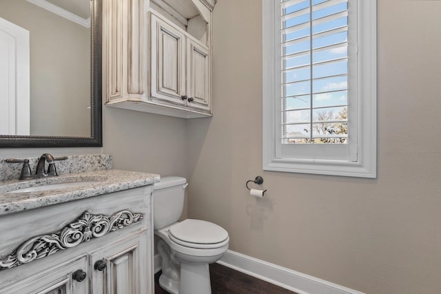 bathroom featuring vanity, crown molding, wood-type flooring, and toilet