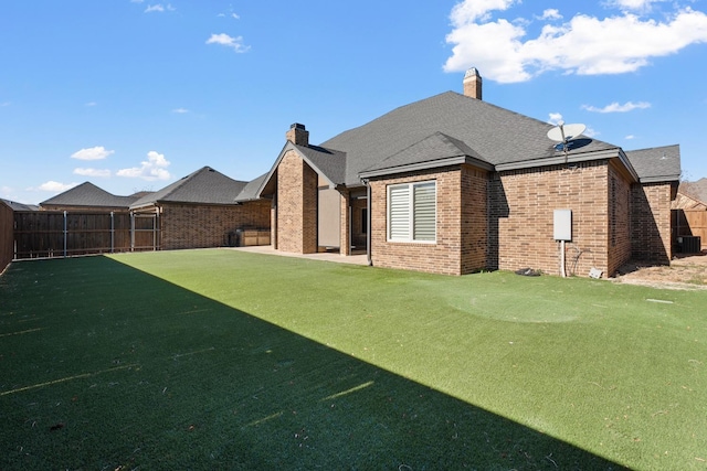 back of house with a patio area and a lawn