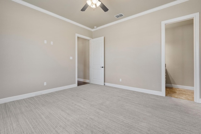 spare room with ornamental molding, light carpet, and ceiling fan