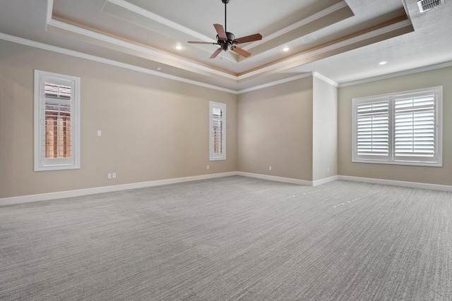 carpeted spare room featuring ceiling fan, ornamental molding, and a tray ceiling