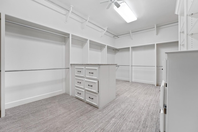 walk in closet featuring light colored carpet and ceiling fan