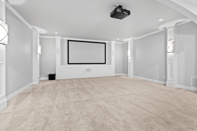 cinema room featuring ornamental molding, light colored carpet, and ornate columns