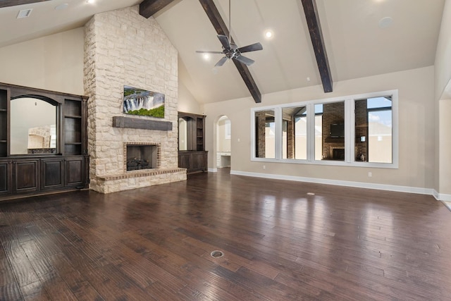 unfurnished living room with dark hardwood / wood-style floors, a fireplace, high vaulted ceiling, and beam ceiling