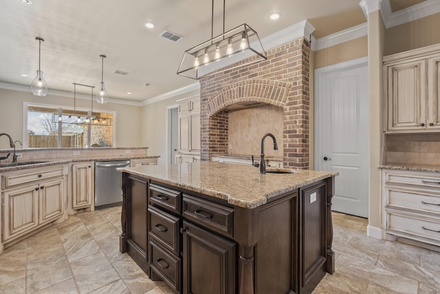 kitchen featuring sink, stainless steel dishwasher, light stone counters, cream cabinets, and a center island with sink