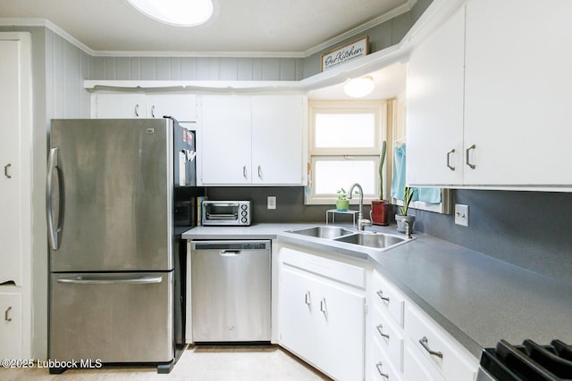 2806 58th St, Lubbock, TX 79413 - kitchen with appliances with stainless steel finishes, a sink, white cabinetry, and ornamental molding