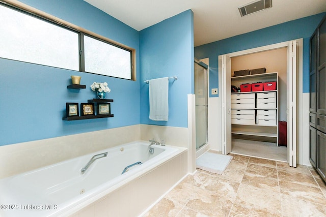 2806 58th St, Lubbock, TX 79413 - bathroom featuring a shower stall, a bath, and a spacious closet