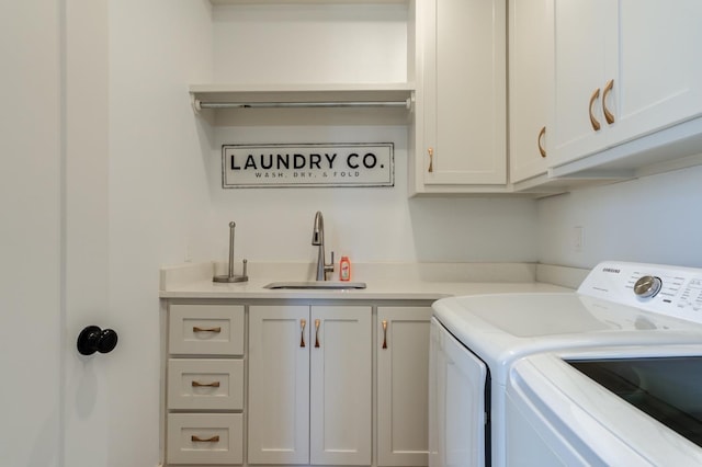 clothes washing area featuring cabinets, sink, and washing machine and clothes dryer