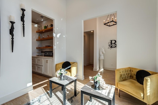 living room featuring a notable chandelier and light wood-type flooring