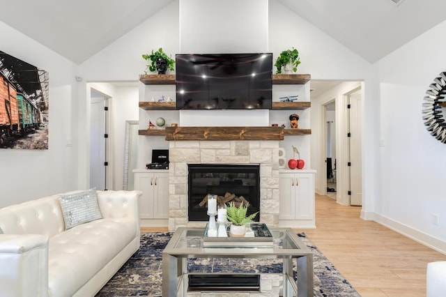 living room with lofted ceiling, a fireplace, and light wood-type flooring