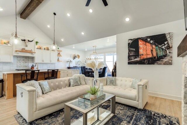 living room featuring high vaulted ceiling, beam ceiling, light hardwood / wood-style floors, and ceiling fan