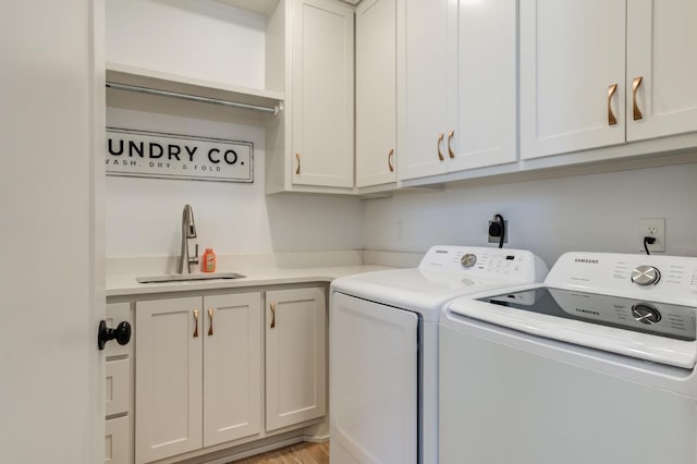 laundry area featuring cabinets, sink, and washer and dryer