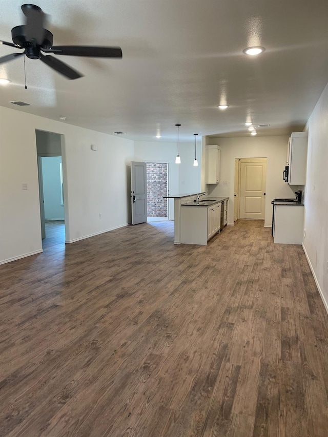 unfurnished living room featuring sink, dark wood-type flooring, and ceiling fan