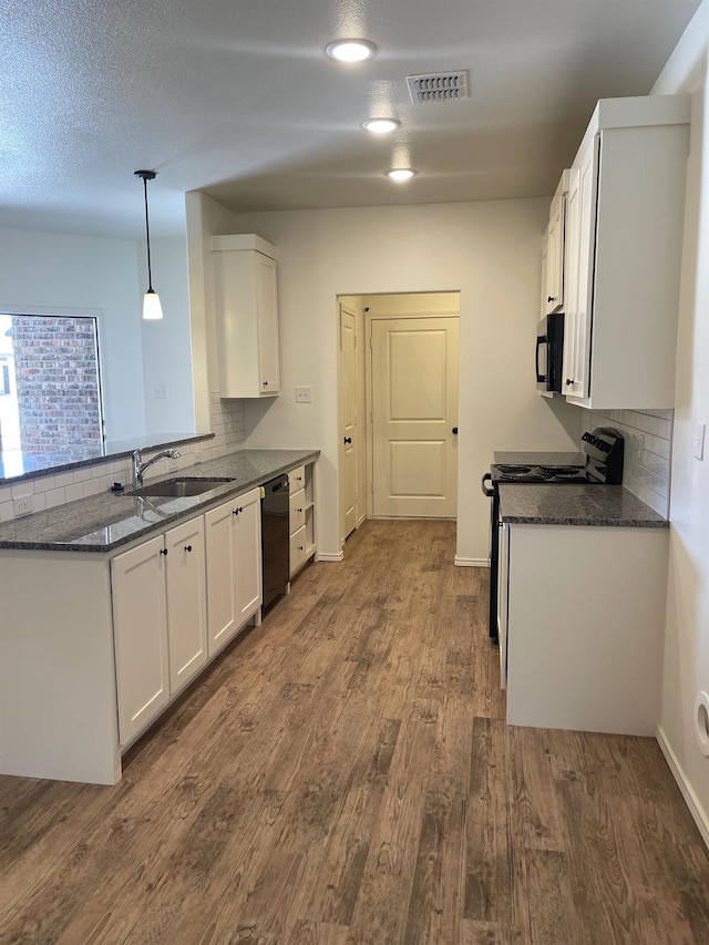 kitchen with dark hardwood / wood-style floors, decorative light fixtures, sink, white cabinets, and black appliances