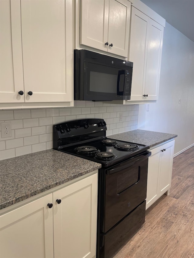 kitchen with stone countertops, white cabinets, decorative backsplash, black appliances, and light wood-type flooring