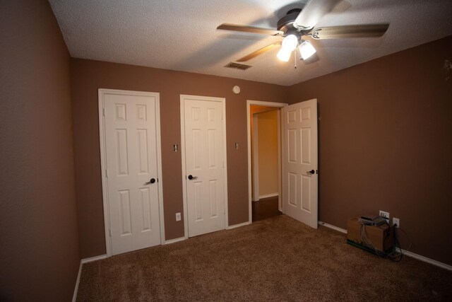 unfurnished bedroom with ceiling fan, carpet floors, and a textured ceiling