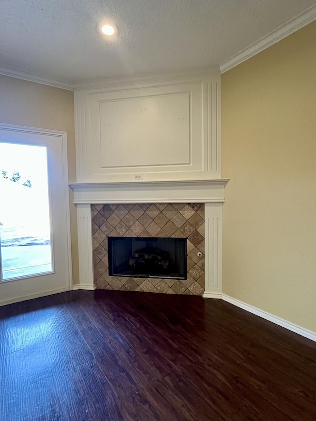 4910 102nd St, Lubbock, TX 79424 - unfurnished living room with ornamental molding, a tiled fireplace, dark wood-style flooring, and recessed lighting