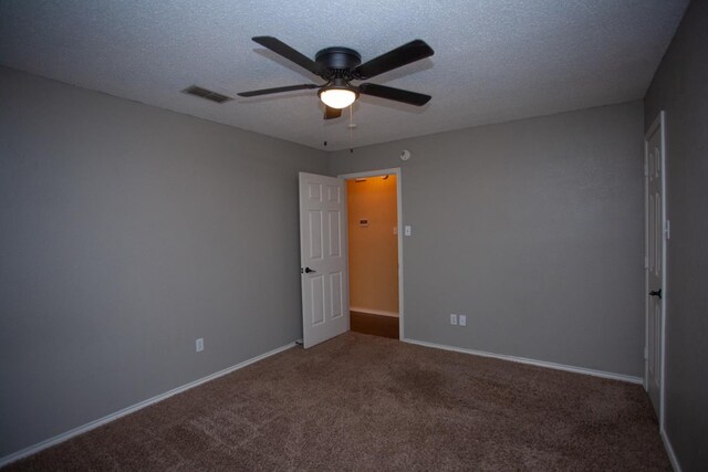 carpeted spare room featuring ceiling fan and a textured ceiling