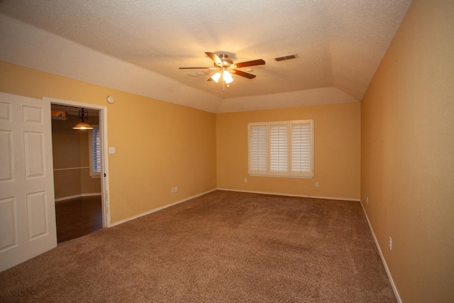 spare room featuring a textured ceiling, vaulted ceiling, ceiling fan, and carpet flooring