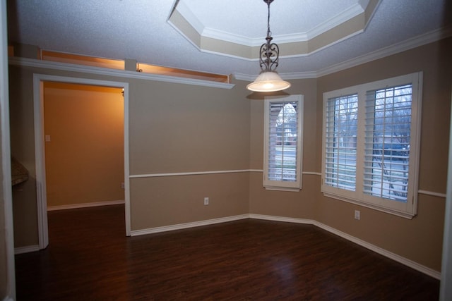 empty room with crown molding, a tray ceiling, and dark wood-type flooring