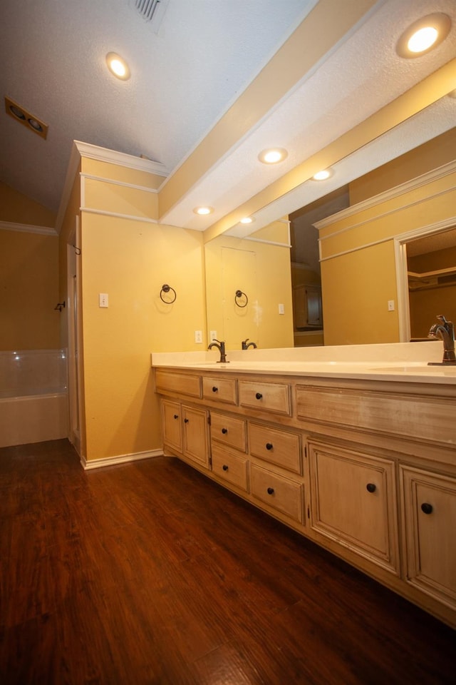 bathroom with crown molding, wood-type flooring, and vanity