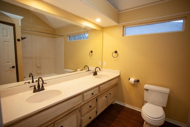 bathroom featuring vanity, vaulted ceiling, hardwood / wood-style floors, and toilet