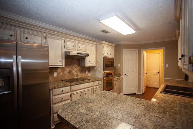 kitchen featuring sink, backsplash, ornamental molding, stainless steel appliances, and cream cabinetry