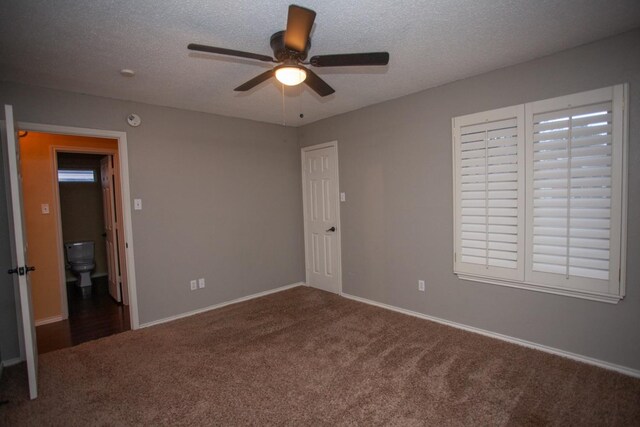 unfurnished bedroom featuring dark colored carpet, ceiling fan, and a textured ceiling