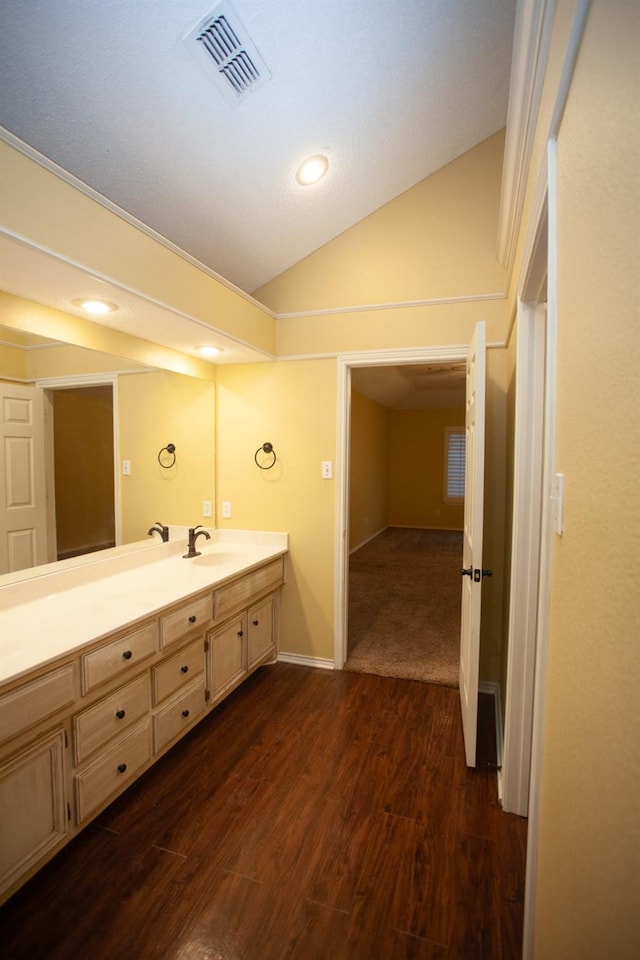 4910 102nd St, Lubbock, TX 79424 - bathroom with vaulted ceiling, wood finished floors, double vanity, and recessed lighting
