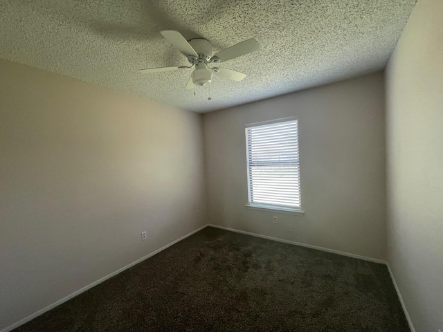 empty room with dark colored carpet, ceiling fan, and a textured ceiling