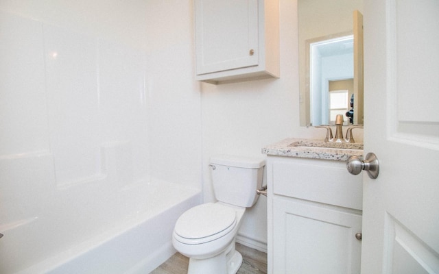 full bathroom with hardwood / wood-style flooring, vanity,  shower combination, and toilet