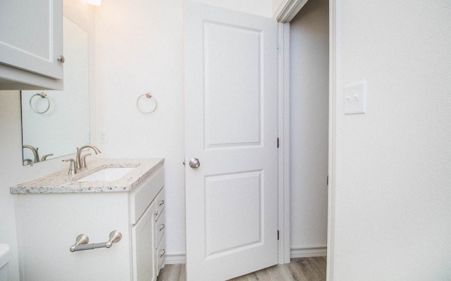 bathroom featuring hardwood / wood-style flooring, vanity, and toilet