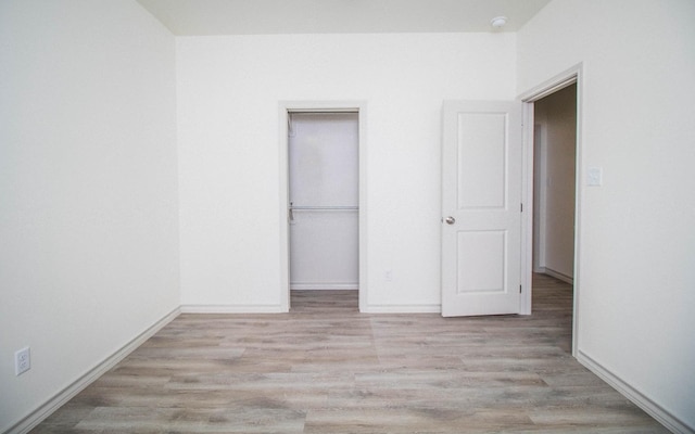 unfurnished bedroom with a closet and light wood-type flooring