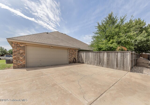 3914 101st St, Lubbock, TX 79423 - view of side of property featuring brick siding, driveway, an attached garage, and a shingled roof