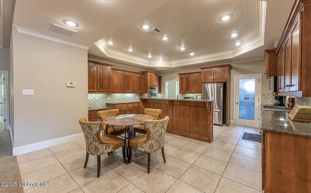 3914 101st St, Lubbock, TX 79423 - kitchen with stainless steel appliances, a tray ceiling, crown molding, decorative backsplash, and light tile patterned floors