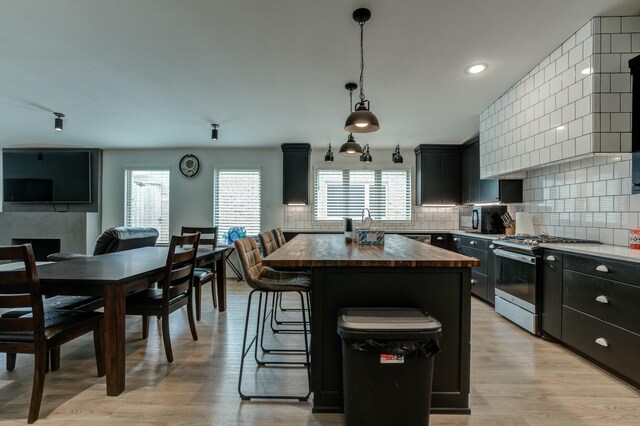 3711 128th St, Lubbock, TX 79423 - kitchen featuring gas range, wooden counters, a kitchen island, tasteful backsplash, and recessed lighting