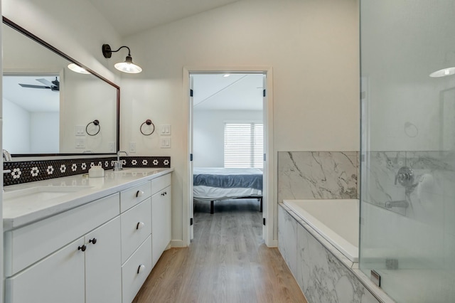 3711 128th St, Lubbock, TX 79423 - bathroom with double vanity, wood finished floors, a garden tub, ceiling fan, and a marble finish shower