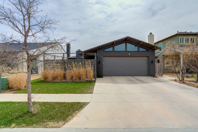 3711 128th St, Lubbock, TX 79423 - mid-century inspired home with concrete driveway, a garage, a chimney, and brick siding