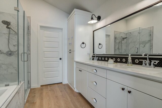 3711 128th St, Lubbock, TX 79423 - bathroom featuring a marble finish shower, double vanity, wood finished floors, a bath, and lofted ceiling