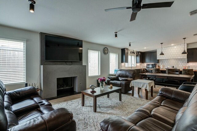 3711 128th St, Lubbock, TX 79423 - living area with ceiling fan, light wood-type flooring, and a fireplace