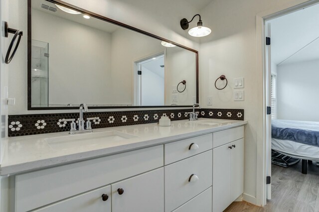 3711 128th St, Lubbock, TX 79423 - full bathroom featuring double vanity, ensuite bathroom, wood finished floors, and tasteful backsplash