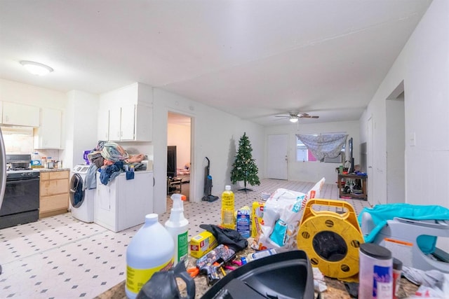 kitchen with white cabinetry, washing machine and clothes dryer, gas range oven, and ceiling fan