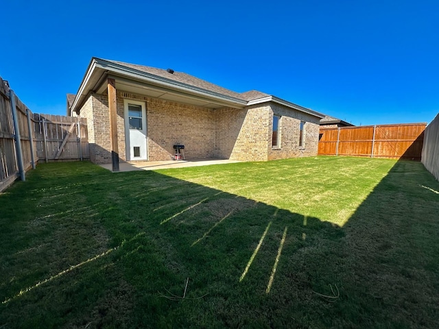 rear view of property featuring a yard and a patio area