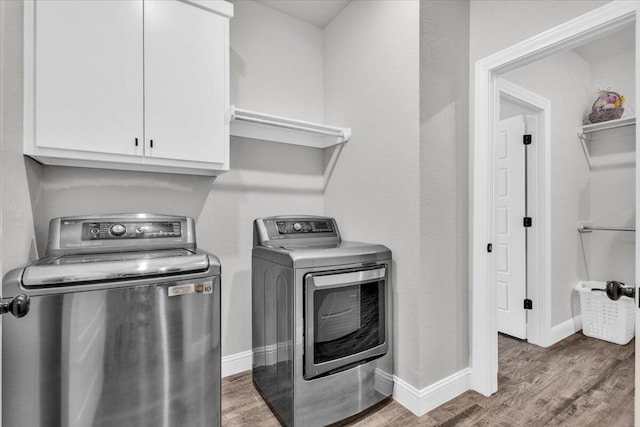 6803 52nd St, Lubbock, TX 79407 - laundry room with cabinet space, washer and clothes dryer, wood finished floors, and baseboards
