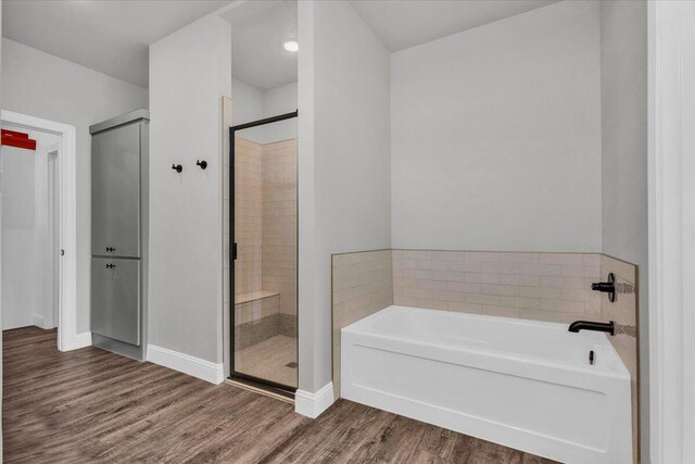 6803 52nd St, Lubbock, TX 79407 - full bath featuring a garden tub, wood finished floors, a stall shower, and baseboards