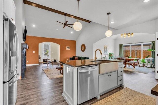 6803 52nd St, Lubbock, TX 79407 - kitchen with stainless steel appliances, arched walkways, open floor plan, high vaulted ceiling, and a sink