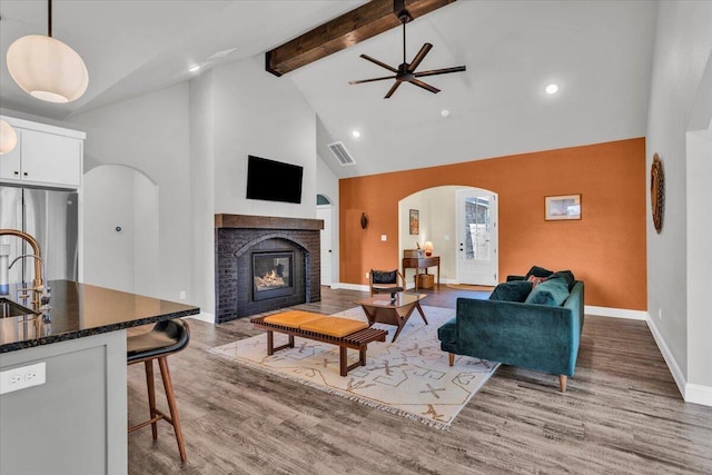 6803 52nd St, Lubbock, TX 79407 - living area with arched walkways, high vaulted ceiling, a ceiling fan, baseboards, and wood finished floors
